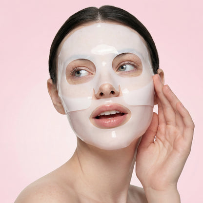 Woman wearing QueenSkin hydrogel face mask on smooth skin, pink background, skincare product