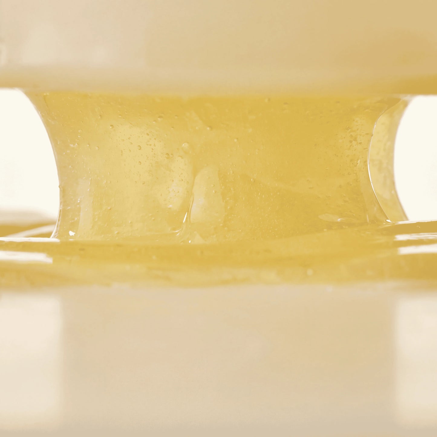 Close-up of QueenSkin hydrogel mask, translucent gold texture, skincare product