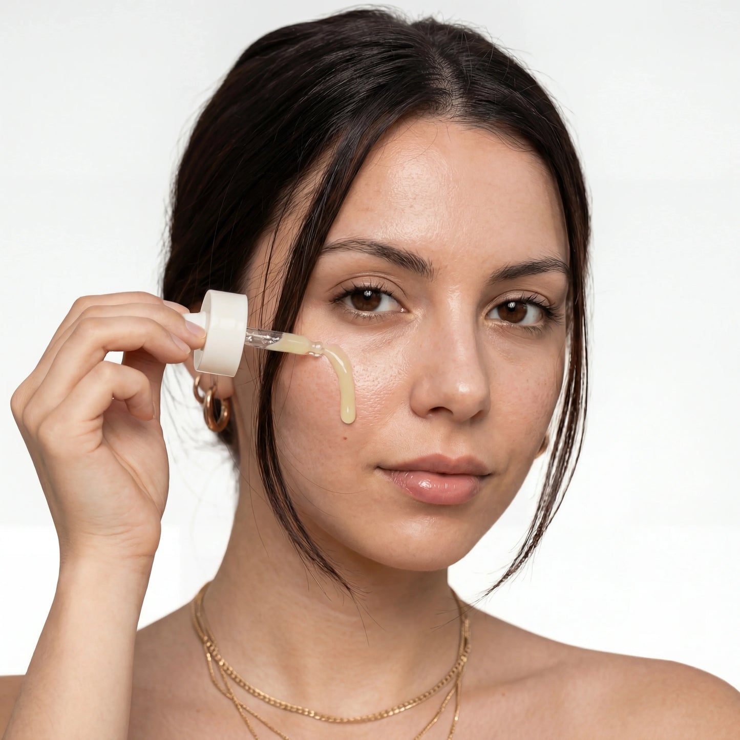 Woman applying QueenSkin serum with dropper, skincare for wrinkles and dry skin