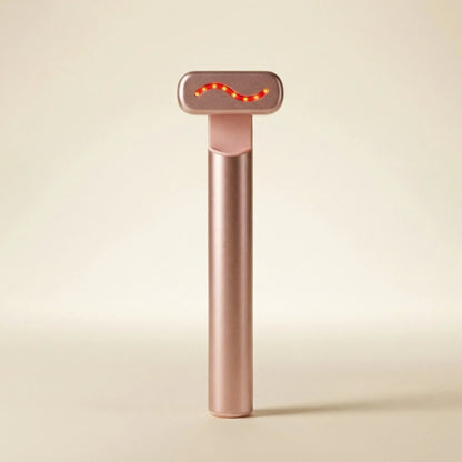 QueenSkin rose gold microcurrent facial device with LED light on beige background