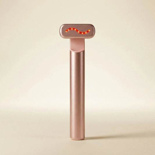 QueenSkin rose gold microcurrent facial device with LED light on beige background